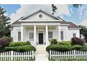 Beautiful single-Gathering home with stately columns, a well-manicured yard, and a white picket fence at 204 Celebration Blvd, Celebration, FL 34747