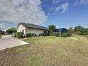 Expansive backyard featuring lush green grass, a screen enclosed pool, and mature landscaping at 2150 Emperor Dr., Kissimmee, FL 34744