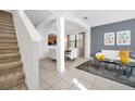 Bright living room with neutral tile floors, comfortable seating, and staircase access at 2628 Tranquility Way, Kissimmee, FL 34746