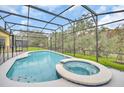 Sparkling swimming pool and hot tub surrounded by a screened enclosure, offering a private oasis at 2628 Tranquility Way, Kissimmee, FL 34746