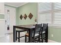 Cozy dining area with light green wall, stylish wood table, and a view to the front entrance through the window at 3428 Sagebrush St, St Cloud, FL 34773