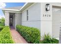 Inviting front entrance with stone pillar, red brick walkway, and lush landscaping leading to the front door at 3428 Sagebrush St, St Cloud, FL 34773
