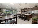 Modern kitchen with stainless steel appliances, a center island, and an open floor plan to dining and living area at 3428 Sagebrush St, St Cloud, FL 34773