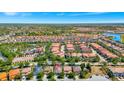Beautiful aerial view of a neighborhood with houses with red roofs, lush trees, and a tranquil lake at 4416 Acorn Ct, Davenport, FL 33837