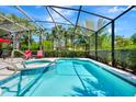 Refreshing screened-in pool with a hot tub, lounge chairs, and lush landscaping, ideal for outdoor enjoyment at 4416 Acorn Ct, Davenport, FL 33837