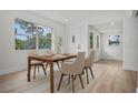 Bright dining room with a view into the front yard through a large window. Features new, light-colored wood flooring at 4420 Lake Lawne Ave, Orlando, FL 32808