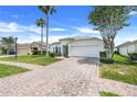 Attractive single-story home with a brick driveway, attached two-car garage, and manicured front yard at 4796 Cumbrian Lakes Dr, Kissimmee, FL 34746