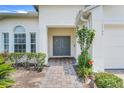 Close-up of the home's front entrance, featuring double doors and a brick pathway surrounded by greenery at 4796 Cumbrian Lakes Dr, Kissimmee, FL 34746
