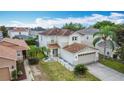 A lushly landscaped two-story home with a two-car garage, featuring palm trees and green grass at 521 Rena Dr, Davenport, FL 33897