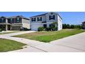 Charming two-story house with a spacious driveway, lush green lawn, and classic architectural details at 673 Sarner Pass Way, Winter Haven, FL 33881