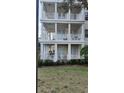 Close-up view of the condo's three-story exterior with spacious, columned balconies and well-kept garden at 7509 Mourning Dove Cir # 303, Reunion, FL 34747