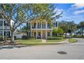 Charming two-story home boasts dual balconies, a manicured lawn, and mature trees at 7550 Gathering Dr, Reunion, FL 34747
