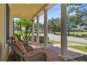 Covered front porch with brick pavers and classic columns, perfect for relaxing outdoors at 7550 Gathering Dr, Reunion, FL 34747