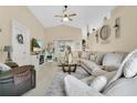 Inviting living room featuring a comfortable sectional sofa, ceiling fan, and elegant decorations at 906 Elm Forest Dr, Minneola, FL 34715