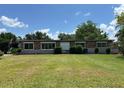 A single-story brick home featuring white-trimmed windows and manicured bushes at 930 Aultman Rd, Kissimmee, FL 34744