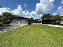 Spacious detached two-car garage and covered carport with a large grass area at 930 Aultman Rd, Kissimmee, FL 34744