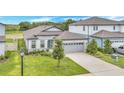 Beautiful single-Gathering home with a two-car garage, blue front door, and landscaped front yard at 983 Silverlake Blvd, Lake Alfred, FL 33850