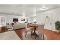 Stylishly furnished living room with hardwood floors, area rug, and dining area at 1055 N Chickasaw Trl, Orlando, FL 32825