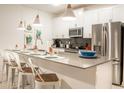 Modern kitchen featuring stainless steel appliances, a large island with seating, and stylish pendant lighting at 1160 Kingsbarn St, Davenport, FL 33896