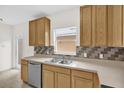 Well-lit kitchen with stainless steel appliances, light wood cabinetry, and tiled backsplash at 13758 Daniels Landing Cir, Winter Garden, FL 34787
