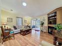 Comfortable living room featuring a fireplace, built-in shelving, and wood laminate flooring at 143 Piedmont Park Ave, Davenport, FL 33897