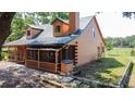 Cozy log cabin featuring a screened-in porch and lush surroundings, ideal for enjoying the peaceful outdoors at 1850 Orangewood Ave, St Cloud, FL 34772