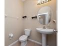 Cozy half bathroom featuring a pedestal sink, modern fixtures, and neutral tones at 1936 Compass Flower Way, Ocoee, FL 34761