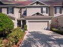 Attractive exterior showcasing a two-story townhouse with an attached garage and landscaped surroundings at 1936 Compass Flower Way, Ocoee, FL 34761