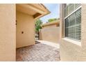 A cozy patio features a brick floor and a stucco wall exterior, next to a window, and a view of a gated area with greenery at 2376 Palm Tree Dr, Kissimmee, FL 34759