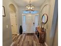 Welcoming foyer with wood-look flooring, elegant lighting, console table and decorative mirror at 2531 Old Kent Cir, Kissimmee, FL 34758