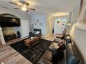 Cozy living room with modern sofas, ceiling fan, and view of the foyer at 2531 Old Kent Cir, Kissimmee, FL 34758