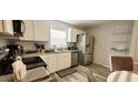 Modern kitchen features white cabinets, stainless steel appliances, and granite countertops at 2729 Club Cortile Cir, Kissimmee, FL 34746