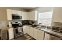 Well-lit kitchen features stainless steel appliances, granite counters, and window at 2729 Club Cortile Cir, Kissimmee, FL 34746