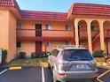Close up view of a condo with red roof, balconies, red railings, and dedicated parking at 2864 N Powers Dr # 150, Orlando, FL 32818