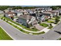 Aerial view of a modern home in a suburban neighborhood, showing well-manicured lawn and paver driveway at 2922 Crest Dr, Kissimmee, FL 34744