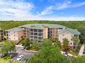 Beautiful condo building surrounded by mature trees, offering an elegant exterior and convenient parking at 3060 Pirates Retreat Ct # 309, Kissimmee, FL 34747