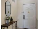 Inviting entryway featuring a stylish console table with decorations and a sleek oval mirror by the door at 3060 Pirates Retreat Ct # 309, Kissimmee, FL 34747