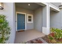 Inviting front porch with stylish blue door, white trim, and decorative landscaping at 3575 Landing Net Dr, Kissimmee, FL 34746