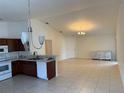 Open kitchen features sleek appliances, tile floor, and a view to the living area at 369 St Georges Cir, Eagle Lake, FL 33839
