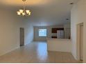 Open-concept living room features tile flooring, a modern chandelier, and lots of light at 369 St Georges Cir, Eagle Lake, FL 33839