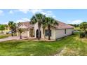Lovely exterior view highlighting the attached garage, desert landscaping, and classic architectural details of this single Gathering home at 3881 Shoreside Dr, Kissimmee, FL 34746