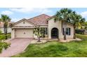 Charming home featuring a brick driveway, arched entry, and well-maintained landscaping and an attached two-car garage at 3881 Shoreside Dr, Kissimmee, FL 34746