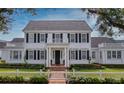 Classic white home with symmetrical design, black shutters, and neat landscaping for enhanced curb appeal at 423 Arbor Cir, Celebration, FL 34747
