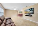Spacious living room featuring tile floors, a ceiling fan, and a mounted television at 4412 Mesa Verde Dr, St Cloud, FL 34769