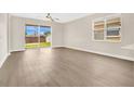 Bright, airy living room featuring wood-look floors, large windows, and sliding glass doors at 5114 Olde Kerry Dr, Orlando, FL 32837
