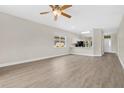 Open-concept living space with wood-look floors, lots of natural light, and a view of the kitchen at 5114 Olde Kerry Dr, Orlando, FL 32837