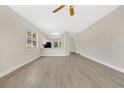 Spacious open-concept room with wood-look floors and a view of the kitchen at 5114 Olde Kerry Dr, Orlando, FL 32837