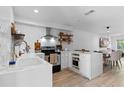 Open kitchen with white cabinets, a center island, stainless steel appliances, and a view of the adjacent dining area at 5234 Eaglesmere Dr # D04, Orlando, FL 32819