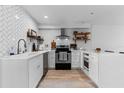 Modern kitchen with white cabinets, quartz countertops, stainless steel appliances, and charming open shelving at 5234 Eaglesmere Dr # D04, Orlando, FL 32819
