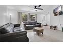 Inviting living room with two leather couches, tile floors, and natural light from large windows at 5234 Ohio St, Winter Park, FL 32792